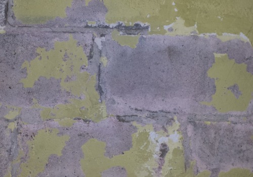 How are water-damaged concrete block walls repaired?